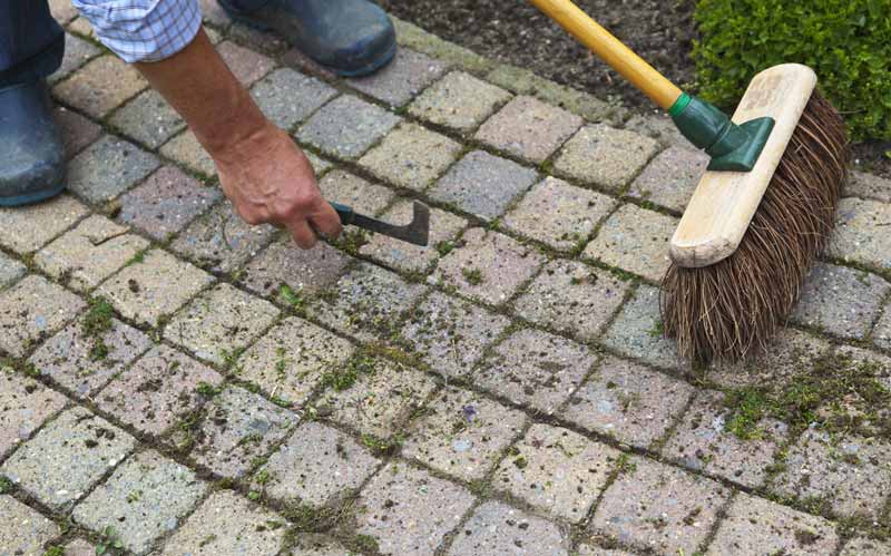 Man sweeping cleaning sidewalk