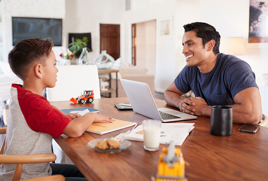 Father and Son at home sitting at a table.