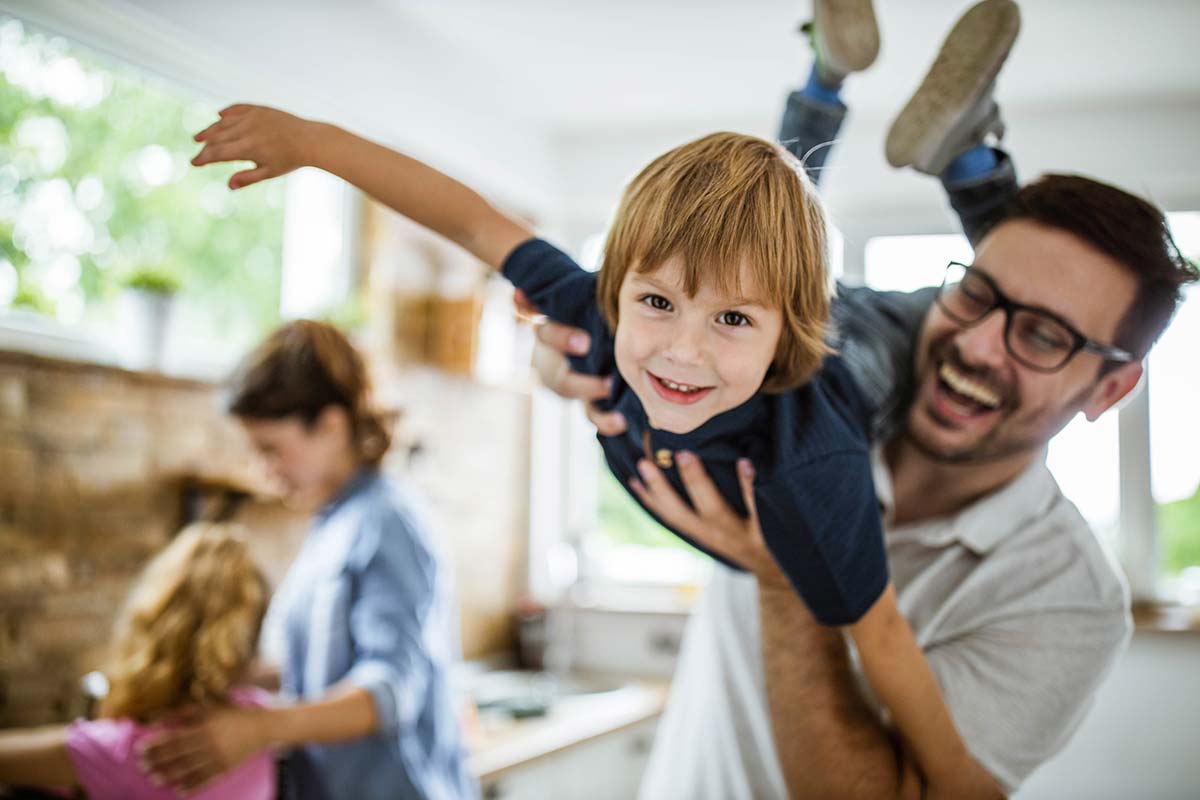 Happy boy having fun with his father in the kitchen